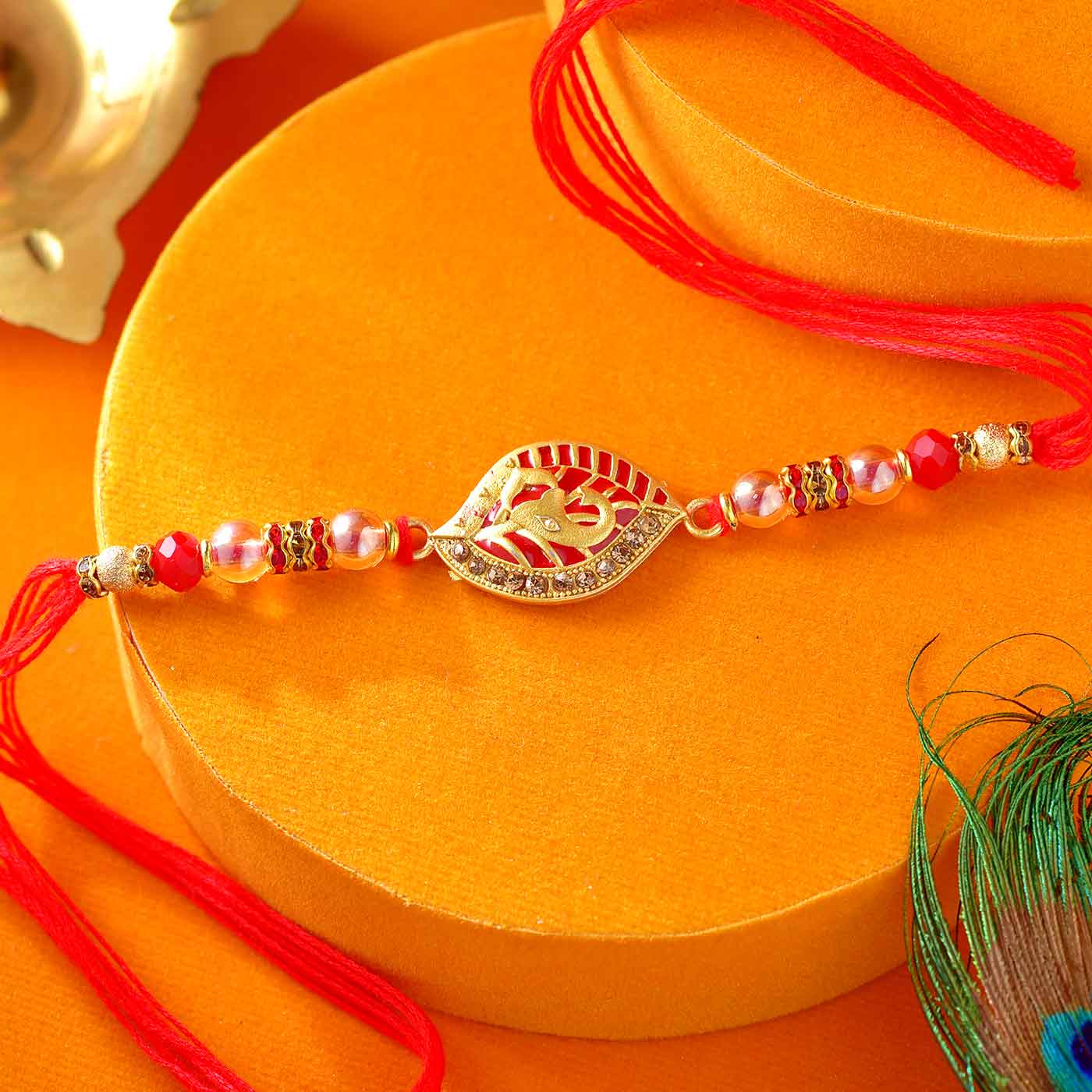 Auspicious Ganesha Rakhi Designed with Pretty Red Pearls - 12 Pcs Pack